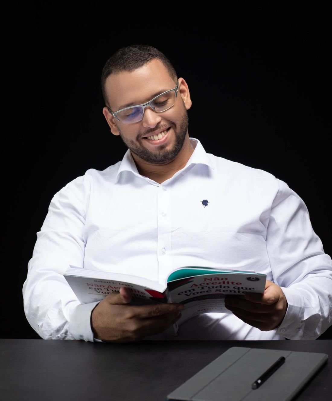 Danilo Melo lendo um livro à mesa