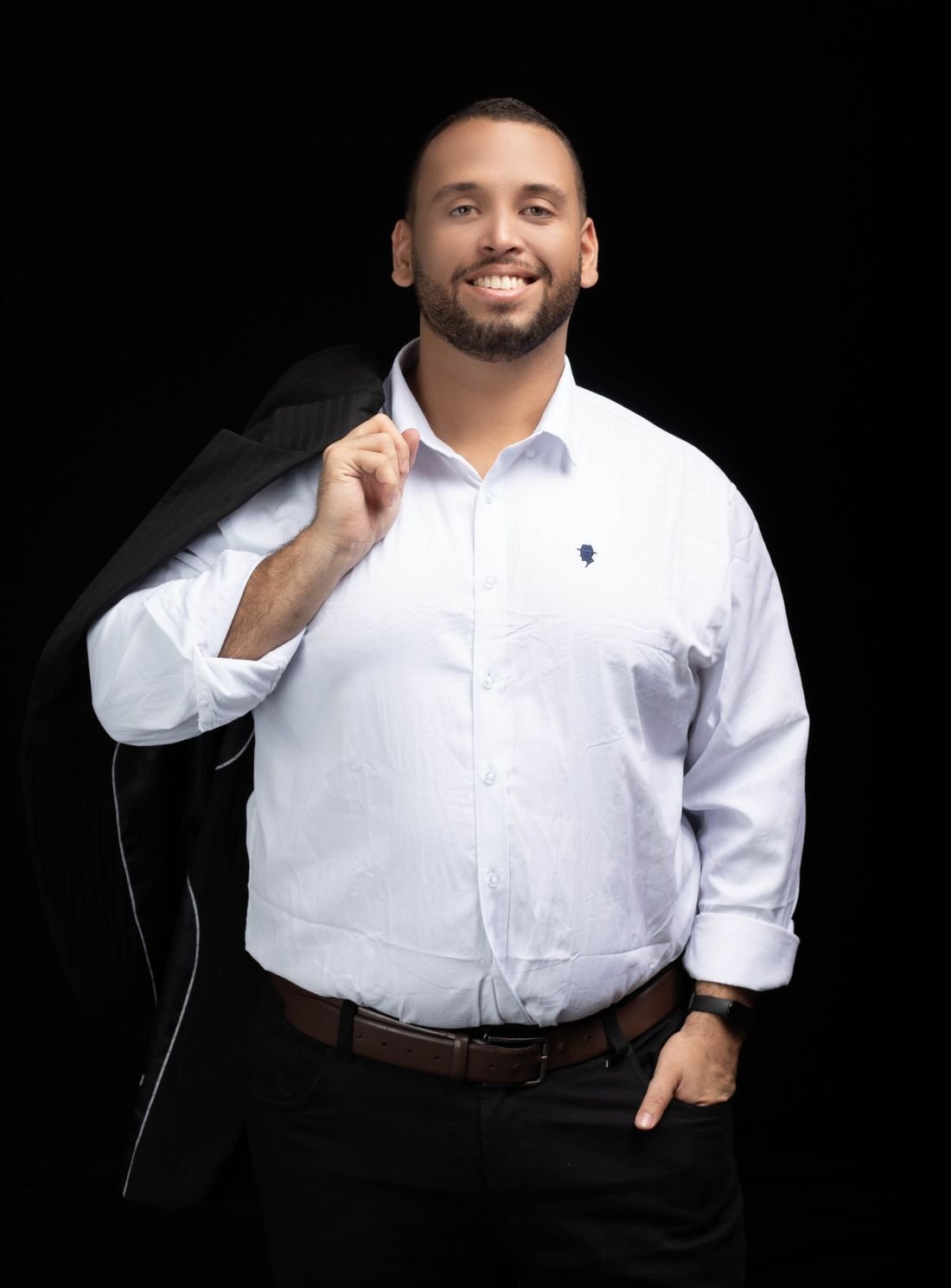 Danilo Melo sorrindo, com o paletó apoiado no ombro
